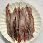 Long, thin crispy duck jerky strips in deep reddish-brown – natural 100% duck dog treats