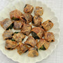Chicken-wrapped brussels sprouts for dogs on a white ceramic plate – homemade natural dog treats