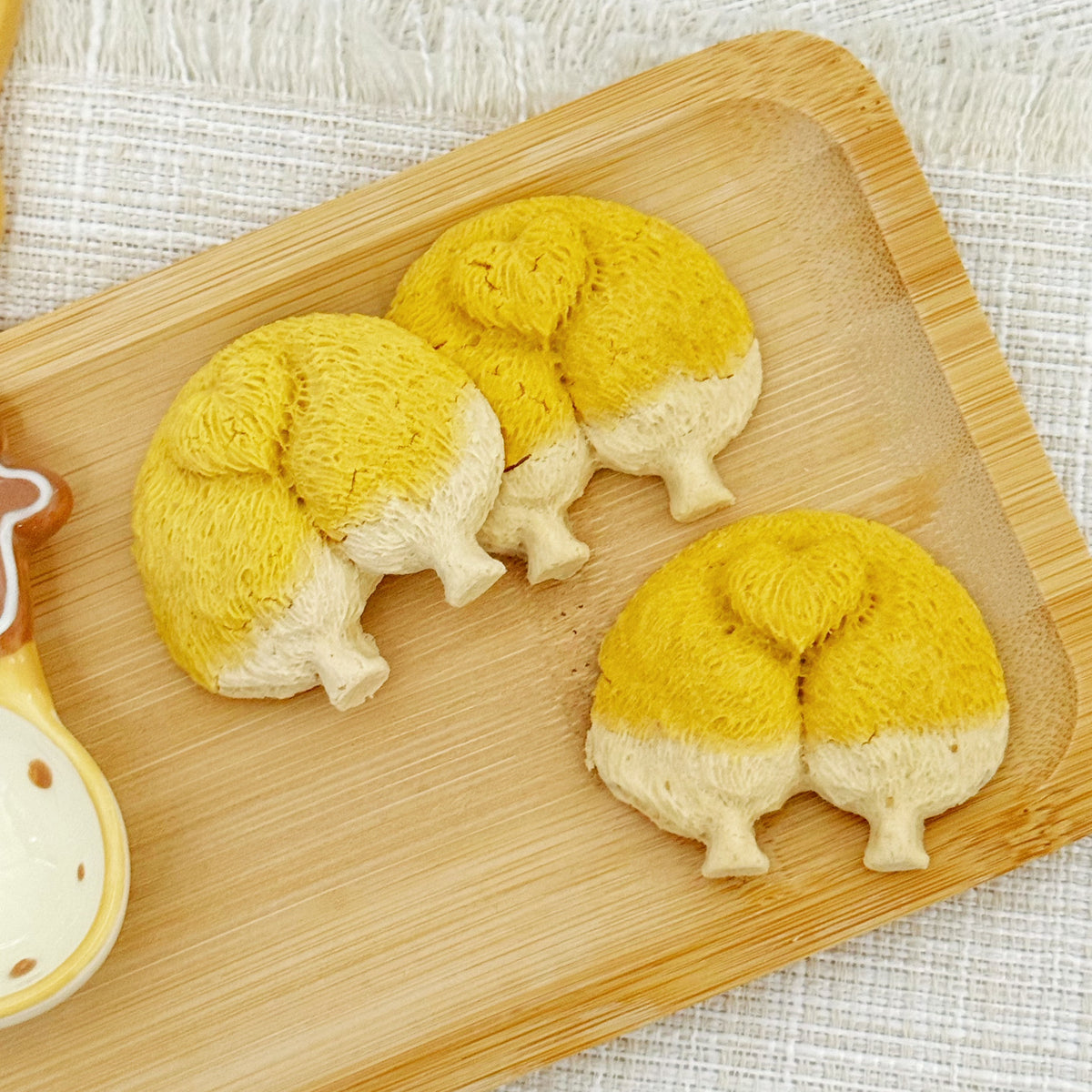 Close-up of a corgi butt cookie showing the golden pumpkin-powder crust and hand-shaped details