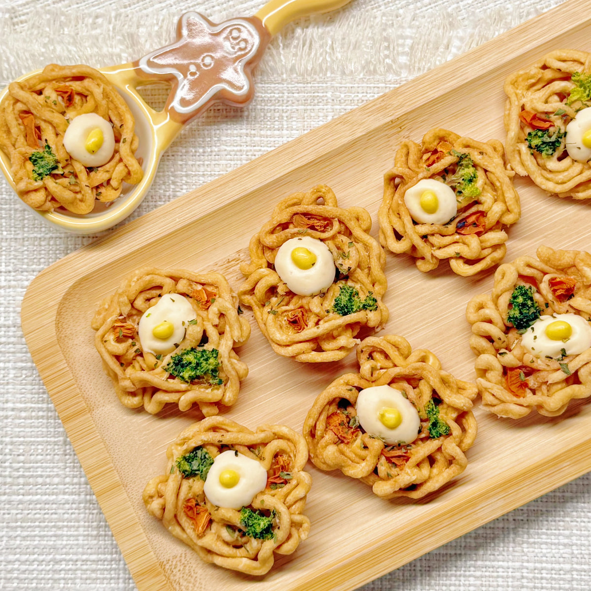 Top-down view of the chicken ramen bites dog treat bowl on a white ceramic plate