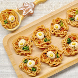 Top-down view of the chicken ramen bites dog treat bowl on a white ceramic plate