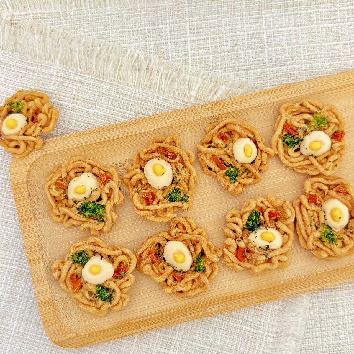 Close-up of the tiny ramen bowl dog treat showing the egg yolk topping and vegetable details