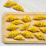 Close-up of a croissant-shaped chicken bite showing its flaky-looking golden layers