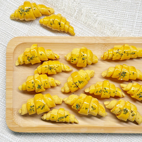 Close-up of a croissant-shaped chicken bite showing its flaky-looking golden layers